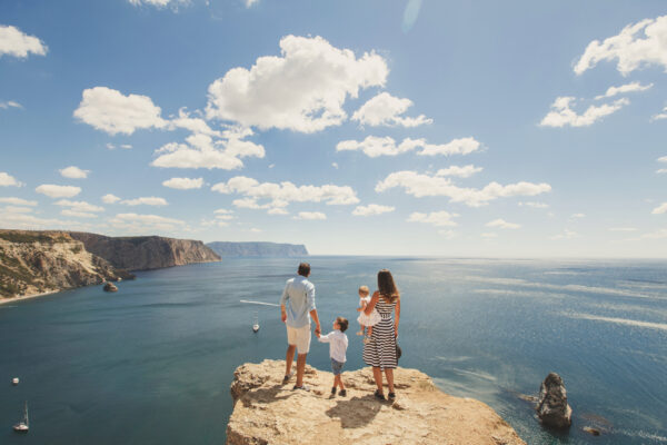 Familie auf Fels am Meer