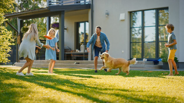 Familie mit Kindern spielen im Garten, Ferienhaus mit großem Grundstück