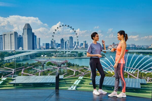 Singapur Marina Bay Supertree Outdooraktivitäten Sport Wellness zwei Frauen auf dem Dachgarten mit Ausblick auf die Stadt und den Singapore Flyer, das Riesenrad