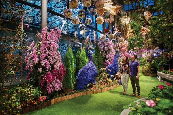 Floral Fantasy Gardens by the Bay in Singapur, ein Paar spaziert an floraler Kunst vorbei