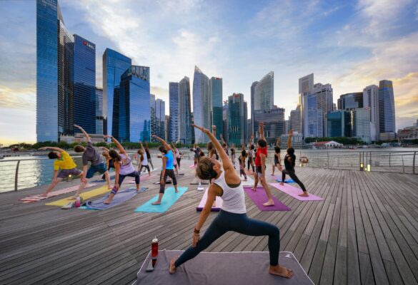 Yoga an der Marina Bay in Singapur hier treffen sich mehrere Gruppen zum gemeinsamen Workout am Morgen