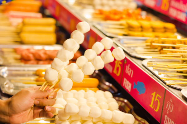 Close up on Woman's Hand Holding Five Fish Ball Sticks in Thailand