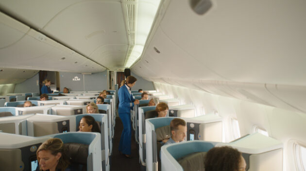 Innenraumansicht eines Flugzeugs von KLM mit Passagieren.