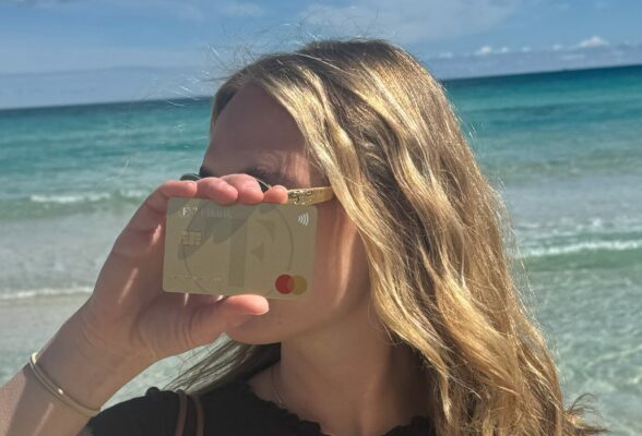 TF Bank Mastercard Gold in Hand vor Gesicht am Strand