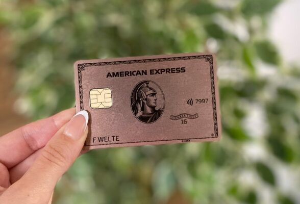 American Express Gold Rose Kreditkarte zwischen Fingern
