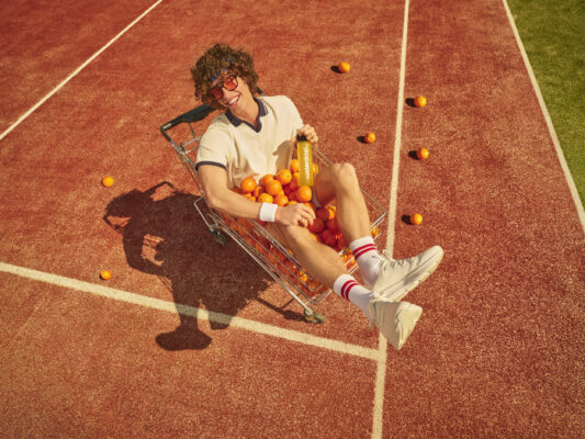 Ein Mann beim Tennis, der eine waterdrop Wasserflasche in der Hand hält
